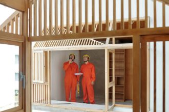 Professionnels discutant d'une extension en ossature bois pour une maison