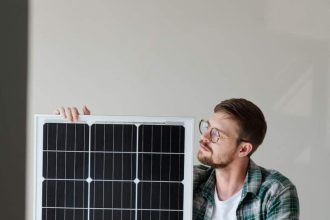 Homme enthousiaste tenant un panneau solaire Plug and Play