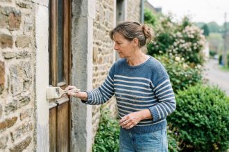 Femme peignant la façade d'une maison en Ardennes
