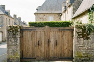 Portail plein en bois massif devant une maison traditionnelle française offrant une intimité totale depuis la rue